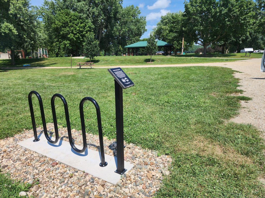 Black bike and kayak rack on concrete at a park
